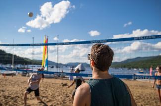 Adultes en train de jouer une partie de volley-ball de plage, club plage et tennis, lac Tremblant, Mont-Tremblant