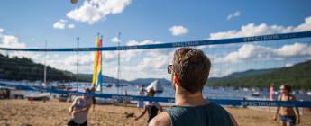 Adultes en train de jouer une partie de volley-ball de plage, club plage et tennis, lac Tremblant, Mont-Tremblant